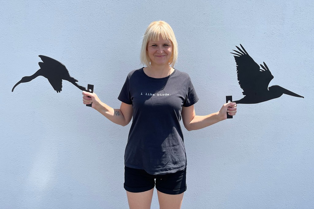Luci i like birds Westphal holding her two metal bird silhouettes, an ibis and a pelican, originated as photos