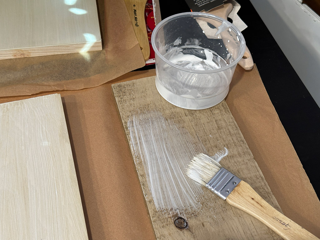 applying gesso to reclaimed fence wood