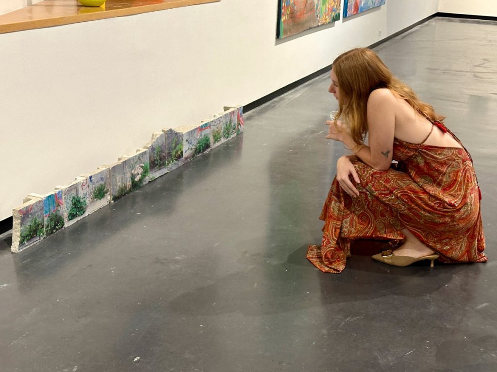 Gillian Probert looking at the installation "Papi's Garten" by Luci Westphal at Creative Pinellas Gallery