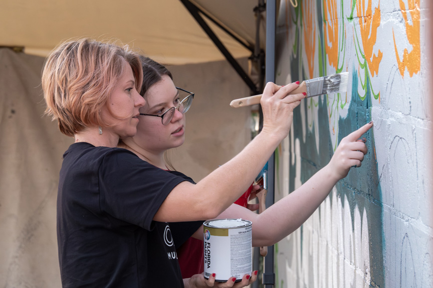 Jenipher Chandly and daughter painting Shine Origins 2025 mural together