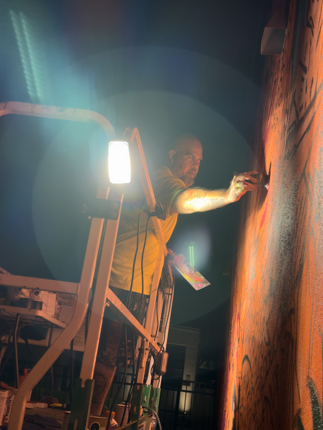 Reid Jenkins painting mural with light flares