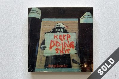 woman holding sign, keep doing shit, video ueberwachung, street art, photo wood transfer,